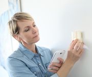 Woman porgramming indoor temperature with smartphone application